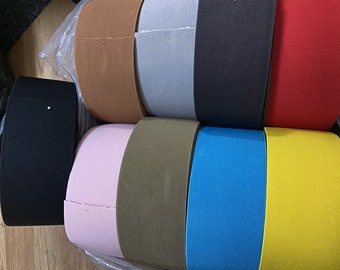 May include: A collection of ten rolls of elastic fabric in various colors, including brown, gray, black, red, pink, green, blue, and yellow.