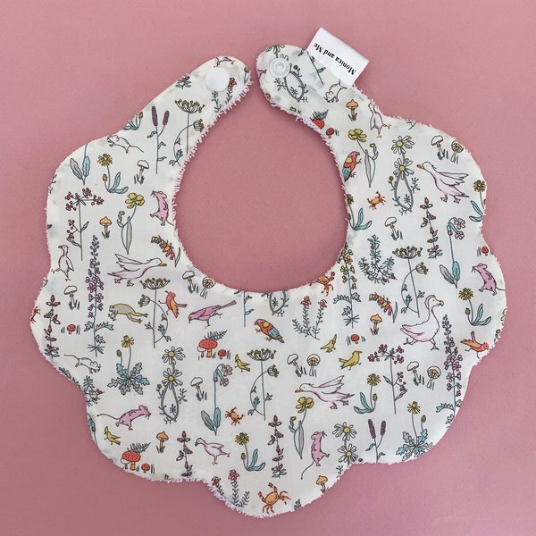 Liberty London Theo rainbow bib in white background, scalloped bib with Terry towelling.