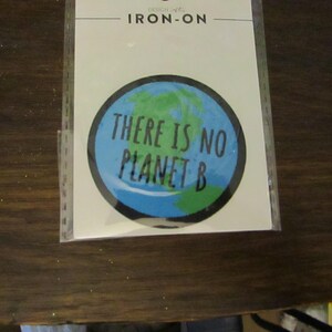 May include: A round iron-on patch with a blue and green image of the Earth and the text "There is no Planet B".