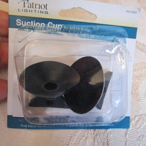 May include: A package of black suction cups for lighting fixtures. The package is labeled "Patriot Lighting" and includes the text "Suction Cup". The suction cups are made of black plastic and are in a clear plastic package.