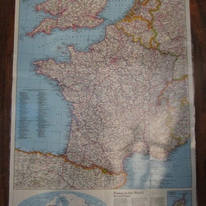 May include: A vintage map of France with a detailed outline of the country's borders and major cities. The map also includes a smaller world map showing France's location and a key with historical information about the country. The map is printed on a light blue background with brown and yellow accents.