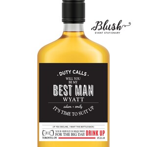 May include: Black and white custom liquor bottle label with the text "Duty Calls. Will you be my Best Man Wyatt adam + emily It's time to suit up" and "Your service is required for the big day Drink Up 07.21.18".