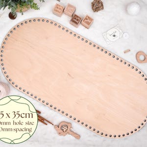 May include: A light-colored wooden oval base with evenly spaced holes around the perimeter. The base measures 75 x 35cm with 10mm hole size and 10mm spacing. The image includes wooden blocks, yarn, and a wooden whale-shaped toy.