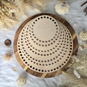 May include: A set of five circular light-colored wooden bases stacked on top of each other. Each wooden disc features a series of evenly spaced holes punched along the outer perimeter, designed for crafting projects like crochet or basket weaving.