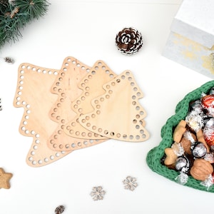 May include: Four unfinished wooden Christmas tree shapes with holes for crocheting. A green crocheted Christmas tree basket filled with chocolates and nuts.