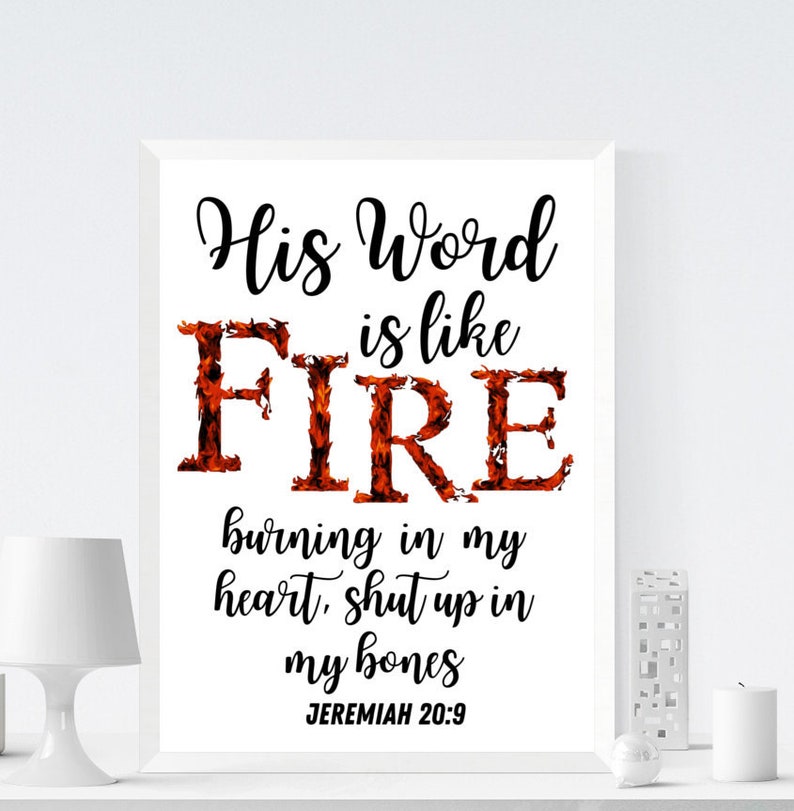 May include: A white framed print with a black and red design. The text reads "His Word is like FIRE burning in my heart, shut up in my bones Jeremiah 20:9".