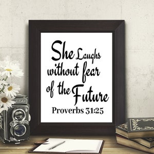 May include: A black and white framed print with the text "She laughs without fear of the future Proverbs 31:25".