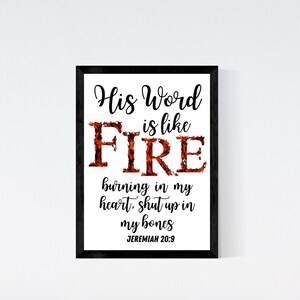 May include: A framed print with a white background and black frame. The print features a black and orange design with the text "His Word is like FIRE burning in my heart, shut up in my bones JEREMIAH 20:9".