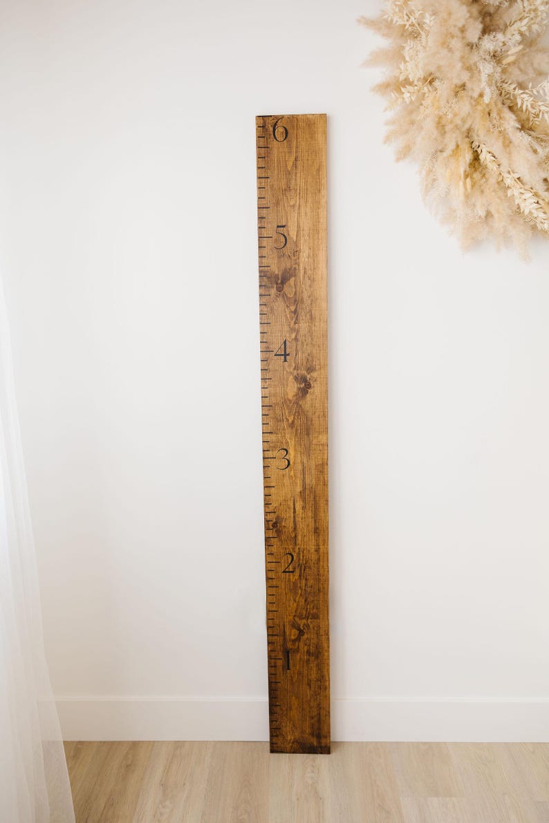 Puede incluir: Un gr&aacute;fico de crecimiento de madera con n&uacute;meros negros del 1 al 6. El gr&aacute;fico est&aacute; te&ntilde;ido de un color marr&oacute;n oscuro y tiene un aspecto r&uacute;stico.
