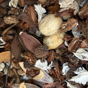 Può includere: Primo piano di una collezione di pot-pourri essiccato. L'immagine presenta una varietà di elementi naturali in tonalità di marrone, beige e bianco. La composizione comprende baccelli, petali e altre forme organiche, creando un'estetica strutturata e terrosa.