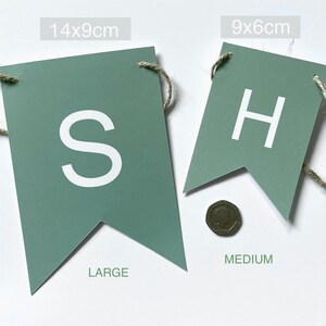 Puede incluir: Dos banderas de fieltro verde con letras blancas. La bandera m&aacute;s grande es de 14x9 cm y dice "S". La bandera m&aacute;s peque&ntilde;a es de 9x6 cm y dice "H".