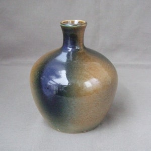 May include: A small, round ceramic vase with a narrow neck. The vase is glazed in shades of blue, green, and brown.