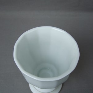 K&ouml;nnte beinhalten: Wei&szlig;e Keramikvase mit geriffeltem Design und einem Sockel.