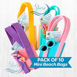 May include: A collection of ten mini beach bags in various colors, including pink, yellow, purple, and teal. Each bag features a handle and is decorated with sunglasses or flip-flops. The bags have a tag that says "Eternal Happiness 2026".