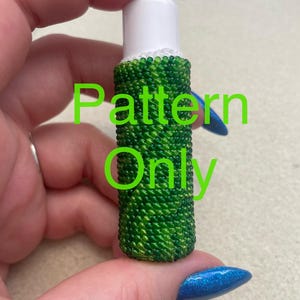 May include: A green and white beaded bottle stopper with a white top. The text "Pattern Only" is written in green letters on the image.