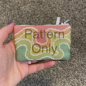 Może przedstawiać: Mała, prostokątna, koralikowa portmonetka z zapięciem na zamek błyskawiczny. Portmonetka ma kolorowy, falisty wzór w odcieniach różu, pomarańczy, żółci i zieleni, ze słowami "Pattern Only" nałożonymi na wzór. Suwak zamka jest biały.