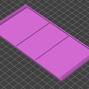 May include: A pink plastic tray with three rectangular compartments. The tray has a textured edge.