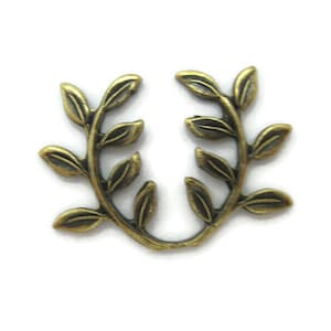 May include: A gold-toned metal charm in the shape of a laurel wreath with leaves.