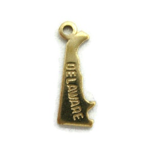 May include: Gold-colored metal charm shaped like the state of Delaware with the word "DELAWARE" inscribed vertically on the charm.