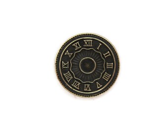 May include: A circular button with a clock face design in an antique style. It has Roman numerals and a dark bronze finish with a gold-coloured rim. The centre has a circular pattern.