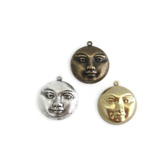 May include: Three metal moon charms with faces, one in silver, one in gold, and one in bronze.