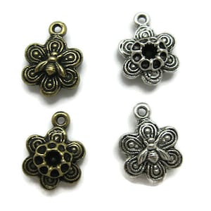 May include: Four silver and bronze flower charms with a bee design. The charms have a loop at the top for attaching to jewelry or other crafts.