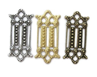 Op de afbeelding: Drie metalen decoratieve versieringen met een parelmoerontwerp. De versieringen zijn in zilver, goud en antiek messing.