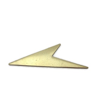 May include: A gold-colored metal arrow shape with a pointed tip.