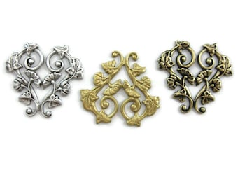 May include: Three ornate metal heart-shaped embellishments with a floral design. The embellishments are silver, gold, and antique gold.