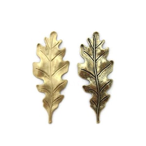 May include: Two gold-toned metal oak leaf charms. One leaf is polished and the other has a distressed finish.