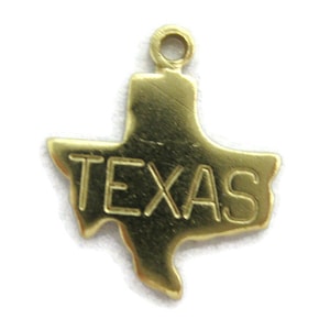 May include: A gold-colored charm in the shape of the state of Texas. The word "TEXAS" is embossed across the center of the charm. The charm has a small loop at the top for attaching to a necklace or bracelet.