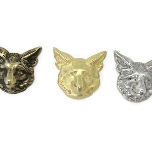May include: Three fox head sculptures in different finishes: antique brass, gold, and silver. Each sculpture is detailed and realistic, capturing the fox's features.