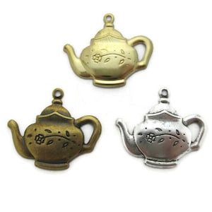May include: Three antique gold and silver teapot charms with floral designs. The charms are perfect for adding a touch of vintage charm to jewelry or crafts.