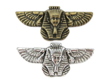 May include: Two winged Egyptian pharaoh head sculptures, one in gold and one in silver.