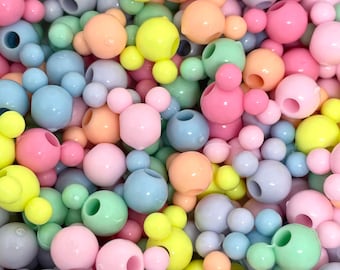 May include: A large assortment of pastel-colored plastic beads in various shapes, including round and Mickey Mouse head designs.