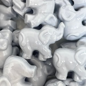 May include: A collection of gray ceramic elephant figurines. The elephants are all different sizes and have a glossy finish.
