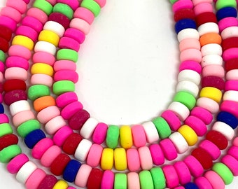May include: A close-up of a multi-colored beaded necklace. The beads are round and have a matte finish. The colors of the beads are pink, yellow, green, blue, white, and red.