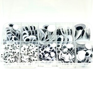 May include: A clear plastic storage box filled with various sizes of googly eyes. The googly eyes are black and white and come in a variety of sizes.