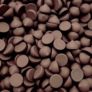 May include: A close-up image of a large pile of dark brown chocolate chips.