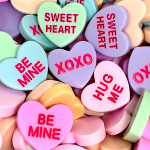 以下が含まれることがあります： 「Sweet Heart」「Be Mine」「XOXO」「Hug Me」など、さまざまなメッセージが書かれたハート型のキャンディー。ピンク、パープル、ブルー、グリーン、イエローなど、さまざまなパステルカラーのキャンディーがあります。