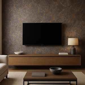 Op de afbeelding: Een moderne woonkamer met een grote zwarte televisie aan een getextureerde muur. Onder de tv staat een lange, houten kast met drie lades. Een lamp met een beige kap staat op de kast en een salontafel met een donkere kom ervoor.