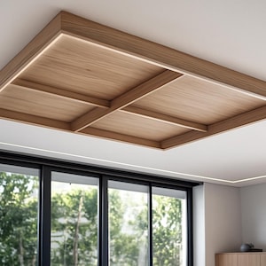 Puede incluir: Una lámpara de techo rectangular de madera con un diseño empotrado. La lámpara está hecha de madera de color claro y presenta un patrón de rejilla. La lámpara de techo está montada en un techo blanco, con una ventana y vegetación en el fondo.