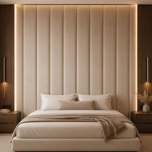 May include: A contemporary bedroom featuring a beige upholstered headboard and a bed with white bedding and a brown throw. The room includes dark wood bedside tables, sconce lighting, and a neutral colour scheme. The design is minimalist and elegant, with a focus on comfort.
