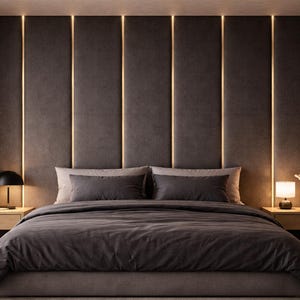 Puede incluir: Un dormitorio con un gran cabecero tapizado en gris oscuro con paneles verticales separados por tiras de luz LED integradas. La cama está vestida con ropa de cama gris oscuro y almohadas a juego, flanqueada por dos mesitas de noche de madera.