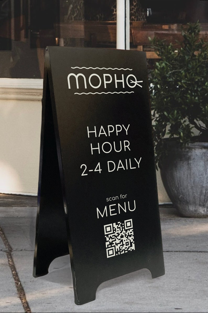 May include: Black A-frame sign with white text that reads "Mopho" and "Happy Hour 2-4 Daily".  The sign also has a QR code with the text "scan for MENU" above it.