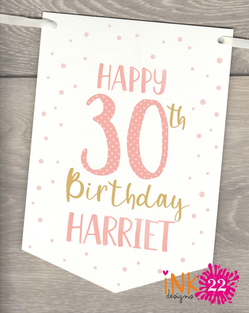 May include: A white banner with pink polka dots and gold lettering. The banner says "Happy 30th Birthday Harriet".
