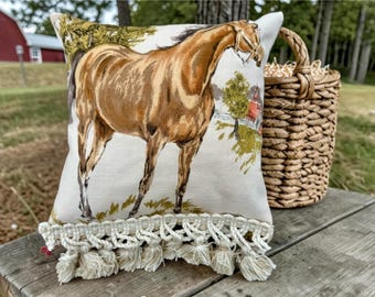 Cojín decorativo vintage con diseño de caballo, caballo castaño y granero rojo, ribete de borlas, fondo textil beige neutro estilo casa de campo, regalo hecho a mano.