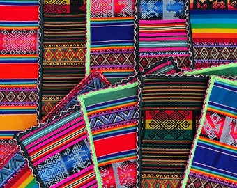 May include: A collection of colorful woven fabric strips with geometric patterns in shades of red, blue, green, yellow, and black. The fabric is arranged in a random pattern, creating a visually appealing and textured surface.