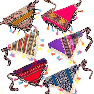 May include: Five colourful, triangular bandanas with patterned fabric and decorative tassels. Each bandana features a unique design, including stripes, geometric patterns, and vibrant colours like pink, purple, and blue. The bandanas have a decorative trim and patterned straps.