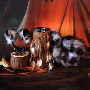 May include: A faux fur tail and matching ears set in black, white, and gray. A black leather collar with a gold buckle sits atop a wooden log, adorned with feathers and beads. A small lantern and a wooden base with a pinecone complete the scene.
